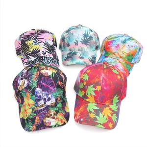 Five assorted baseball caps with tropical leaf and skull prints on a white background