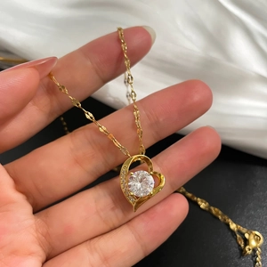 Collana a cuore dorato con micro-pave di cristalli e una grande gemma centrale
