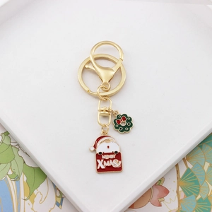 Detail of Christmas keychain with Santa Claus and wreath pendants on white tray