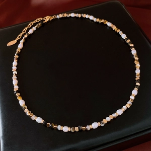 Detailed shot of freshwater pearl necklace with tiger eye beads and gold lobster clasp