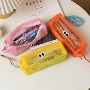 Detail view of mesh pencil cases in pink, orange, and yellow with cartoon eye designs