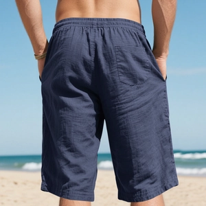 Rear view of navy linen shorts featuring elastic waist and pocket on a sunny beach