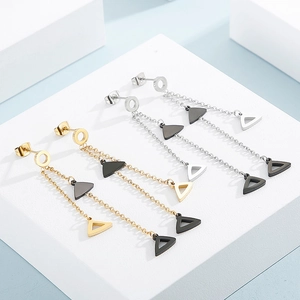 Detail view of gold and silver geometric long tassel earrings with black triangles