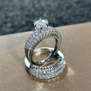 Macro detail of silver wedding ring set with six-prong setting and pavé zircon stones