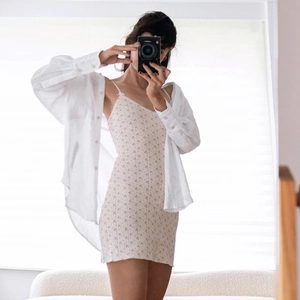 Detail of white floral sundress and matching cardigan on model for a trendy summer look