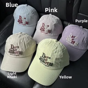 Detailed close-up of embroidered baseball caps in five colors on a leather seat