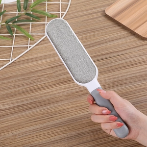 Portable pet hair remover brush with grey fabric and ergonomic white handle for home use