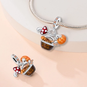 Silver autumn charm detail with mushroom and pumpkin basket on a bracelet