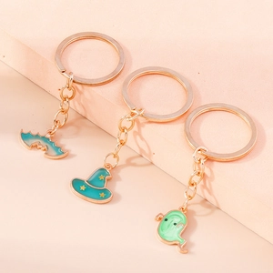 Detailed view of enamel bat, witch hat and ghost pendants on golden keychains