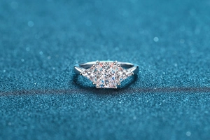 Macro shot of 3-carat radiant cut moissanite ring on sparkly blue background