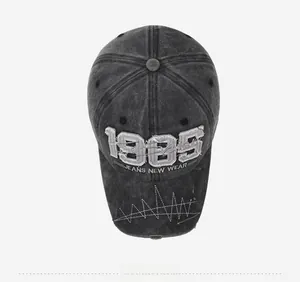 Detail of dark gray vintage baseball cap with 1985 embroidery and distressed brim