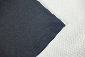 Detailed close-up showing double-needle stitching and high-density black knit fabric texture