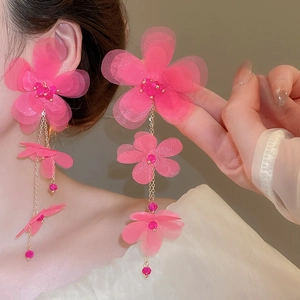 Close-up of pink chiffon flower tassel earrings with delicate tulle petals and beads