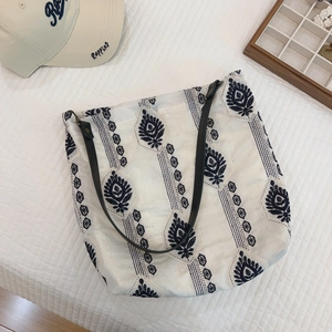 Detail of bohemian leaf embroidery on canvas tote bag with black leather handle