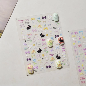 Detail showing macaron color nail art stickers with 3D bow and bunny designs for manicure