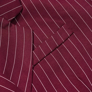 Close-up detail of burgundy pinstripe fabric texture and stitching on suit jacket pocket