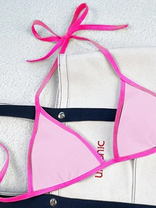 Detail view of light pink triangle bikini top with contrast hot pink tie straps