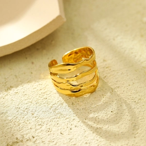 Macro detail of 18K gold plated multi-layer wave ring with textured surface on stone