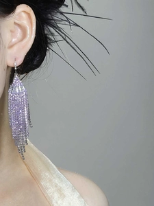 Close-up of purple zircon fringe earrings with fan shape tassel on a model