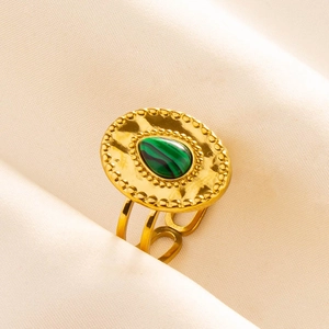 Macro view of vintage gold stainless steel ring with green malachite on silk