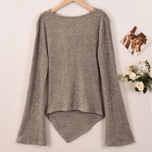 Dettaglio del top in maglia grigio chiaro con trama a costine e orlo asimmetrico