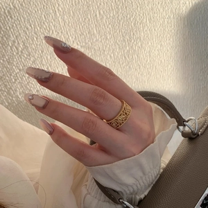 Close-up of a wide 18K gold-plated open ring with retro intricate hollow flower carvings