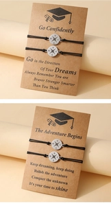 Detail of black woven graduation bracelets with compass charms and inspirational gift cards