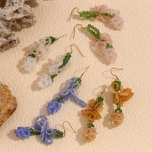 Close-up of colorful beaded flower earrings in pink and blue with 18K gold plating