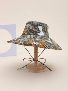 Detail of wide brim sun hat with tropical leaf print and windproof bow strap