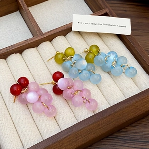 Detail of beaded grape earrings in translucent red, purple, green and blue shades