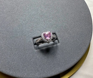 Macro shot of 925 silver ring featuring a heart-shaped pink gem and halo diamonds