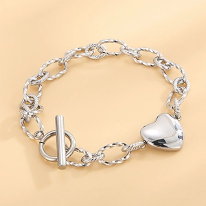 Bracelet en acier inoxydable avec pendentif coeur et fermoir en T sur un fond orange