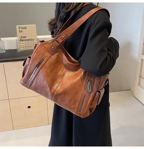 Brown vintage faux leather tote bag with side zippers shown on a model's shoulder