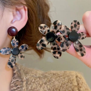 Detailed close-up and model view of vintage acetate flower earrings in leopard print pattern