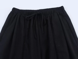 Detail of black linen trousers showing elastic waistband with drawstring closure