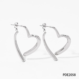 Detailed close-up of polished silver heart earrings with an asymmetric open design