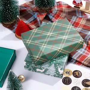 Papier cadeau de Noël en motifs écossais rouges et verts avec décorations de fête