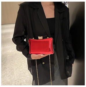 Detailansicht der roten glänzenden Acryl-Box-Tasche mit Strassverschluss und Kette