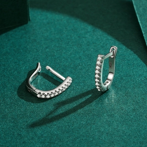 Minimalist S925 sterling silver U-shaped earrings with pavé zircon stones on green backdrop