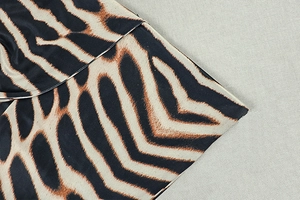 Vue macro détaillée du tissu à imprimé tigre orange et noir à texture lisse