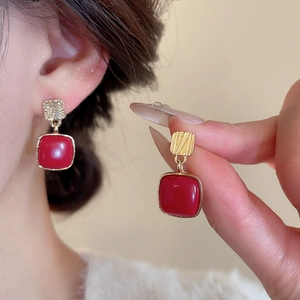 Detail view of retro red square drop earrings with gold metallic brushed texture