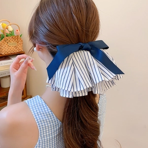 Detailansicht eines Haargummis mit Satin-Schleife und blau gestreiftem Plissee-Stoff