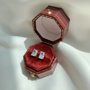 Detailed close-up of rectangle-cut zircon stud earrings in a vintage red velvet box