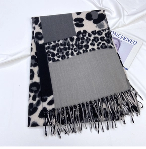Detail of leopard print scarf with geometric color blocks and soft tassel fringe
