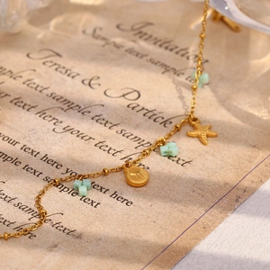 Gros plan détaillé du bracelet océan plaqué or 18 carats avec coquillages et étoiles