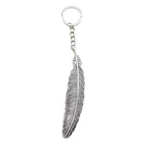 Vintage silver metal feather keychain pendant with chain on white background