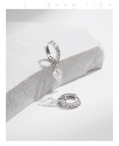 Macro detail of S925 sterling silver hoop earrings with clear geometric zircon pendants
