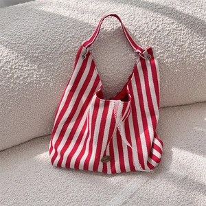 Détail du sac cabas en toile à rayures rouges et blanches avec bordure en dentelle