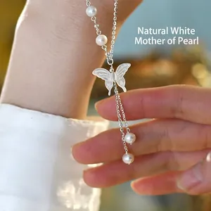 Detailed macro of a 925 silver butterfly necklace with white shell and freshwater pearls