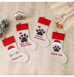 Flat lay of dog and cat paw Christmas stockings with festive slogans on wooden floor